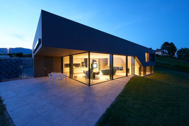 This is an example of a contemporary two floor detached house in Buckinghamshire with metal cladding and a flat roof.