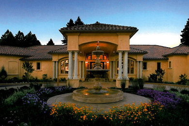 Large tuscan yellow one-story stucco exterior home photo in San Francisco with a hip roof