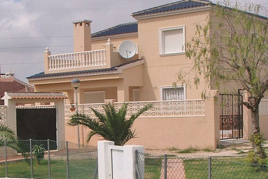 Foto de fachada beige tradicional de tamaño medio de dos plantas con revestimientos combinados y tejado a cuatro aguas