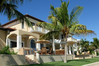 Large mediterranean beige two-story stucco house exterior idea in Miami with a hip roof and a tile roof