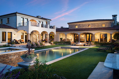Example of a large tuscan beige two-story stucco exterior home design in San Diego with a hip roof