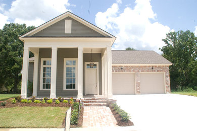 Example of a mid-sized arts and crafts beige one-story brick exterior home design in New Orleans