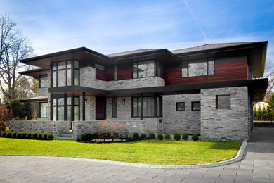 Foto de fachada de casa gris contemporánea grande de dos plantas con revestimiento de piedra, tejado a cuatro aguas y tejado de teja de madera