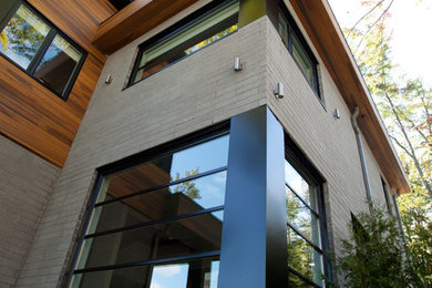 Inspiration for a large contemporary gray two-story mixed siding flat roof remodel in Montreal