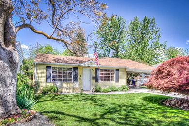 This is an example of a yellow bohemian bungalow house exterior in Boise with wood cladding.