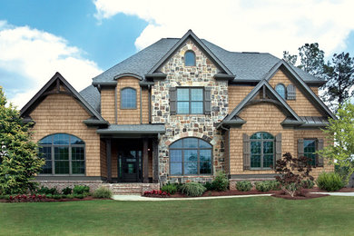 Example of a large trendy brown three-story mixed siding exterior home design in Kansas City with a clipped gable roof