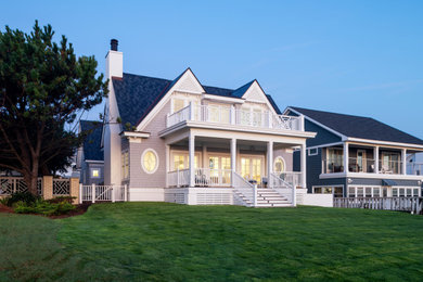 Foto de fachada de casa gris costera de tres plantas con revestimiento de madera y tejado a dos aguas