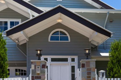 Aménagement d'une façade de maison grise classique en bois de taille moyenne et à un étage avec un toit à deux pans.