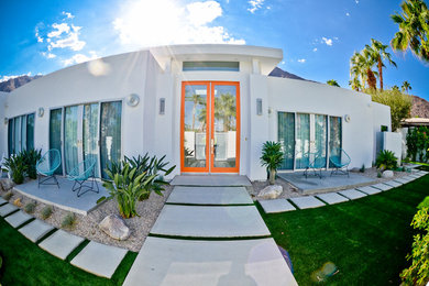 Large trendy white one-story stucco exterior home photo in Other with a mixed material roof