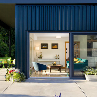 Imagen de fachada azul, contemporánea, de una planta, con revestimiento de metal y tejado plano