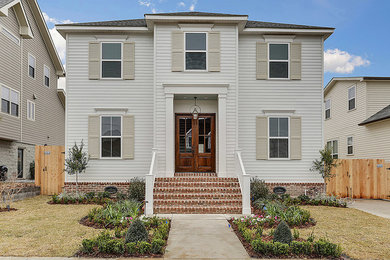 Large elegant white two-story wood house exterior photo in New Orleans with a hip roof and a shingle roof