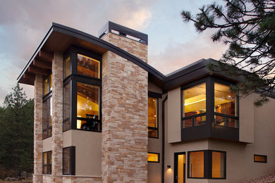 Ejemplo de fachada beige moderna grande de dos plantas con revestimientos combinados y tejado plano