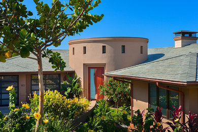 Large southwestern brown two-story stucco exterior home idea in Hawaii