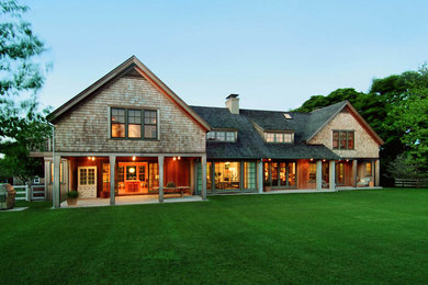 Large trendy brown two-story wood exterior home photo in New York with a shingle roof