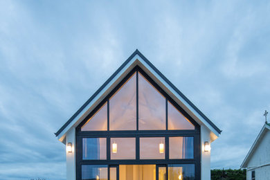 Foto de fachada blanca contemporánea pequeña de una planta con tejado a dos aguas y revestimiento de hormigón