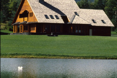 Modelo de fachada de casa marrón rural grande de dos plantas con revestimiento de madera, tejado a dos aguas y tejado de teja de madera