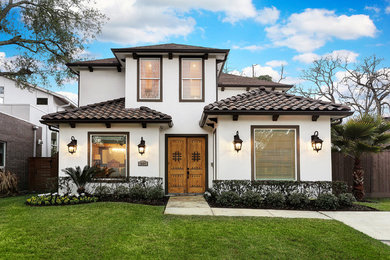 Mid-sized mediterranean white two-story stucco house exterior idea in Houston with a hip roof and a tile roof