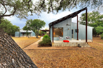 Inspiration for an industrial house exterior in Austin with metal cladding and a lean-to roof.