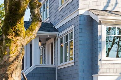 Idée de décoration pour une façade de maison bleue tradition en bois à un étage.
