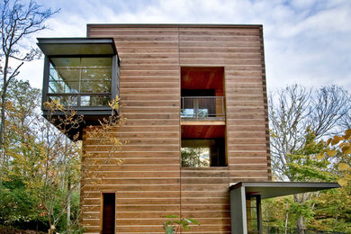 Large trendy brown three-story wood house exterior photo in Cincinnati with a shed roof and a green roof