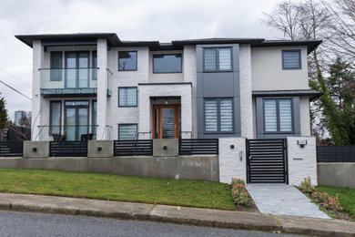 Example of a large trendy white three-story metal house exterior design in Vancouver