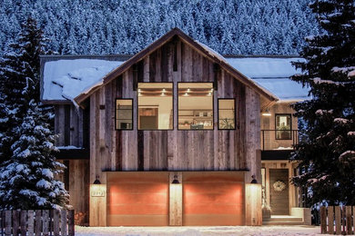 Example of a mountain style two-story wood exterior home design in Other with a metal roof