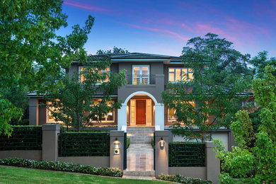 На фото: двухэтажный, коричневый, большой дом в современном стиле с облицовкой из цементной штукатурки и вальмовой крышей