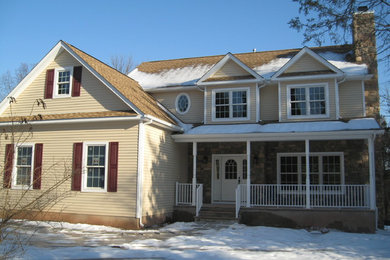 Modelo de fachada de casa beige tradicional grande de dos plantas con revestimientos combinados y tejado de teja de madera