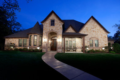 Example of a mid-sized tuscan beige one-story mixed siding exterior home design in Austin with a shingle roof
