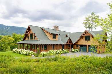 Huge rustic brown two-story wood house exterior idea in Burlington with a clipped gable roof and a green roof