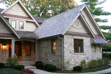 Foto de fachada de casa beige clásica renovada grande de una planta con revestimientos combinados, tejado a dos aguas y tejado de teja de madera