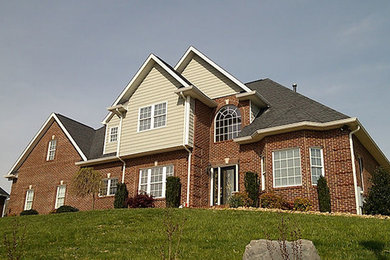 Example of a large classic two-story brick exterior home design in Other with a shingle roof
