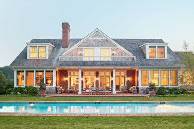 Large elegant brown two-story wood exterior home photo in New York with a shingle roof