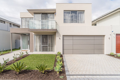 Imagen de fachada de casa blanca minimalista de dos plantas con revestimiento de estuco