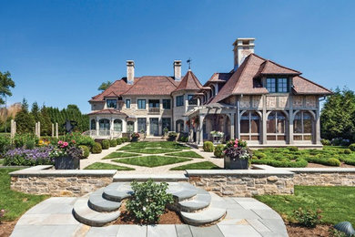 Huge eclectic beige three-story mixed siding house exterior idea in Other with a hip roof and a tile roof