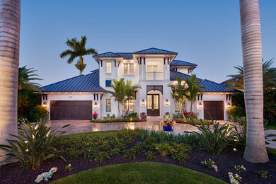 На фото: двухэтажный частный загородный дом в морском стиле с облицовкой из бетона, вальмовой крышей и металлической крышей с