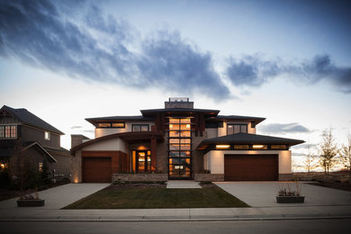 Beige and large contemporary two floor render detached house in Calgary with a hip roof and a shingle roof.