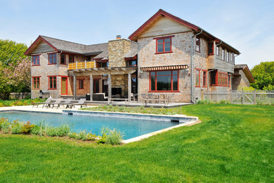 Diseño de fachada marrón de estilo americano grande de dos plantas con revestimiento de madera y tejado a dos aguas