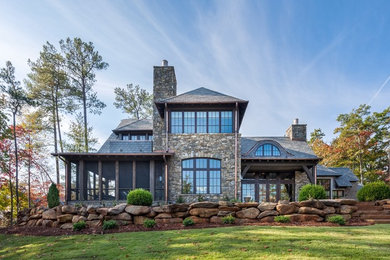 Huge mountain style brown two-story stone gable roof photo in Other