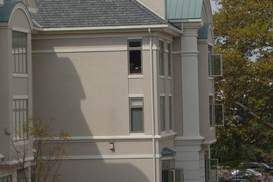 Example of a large tuscan beige three-story stucco gable roof design in Philadelphia