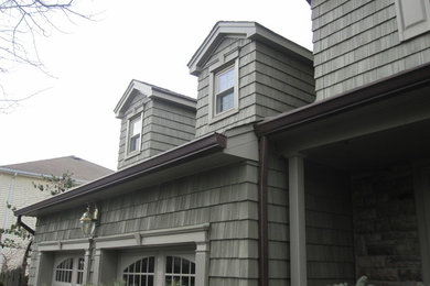Inspiration for a large timeless green two-story vinyl exterior home remodel in Newark with a hip roof