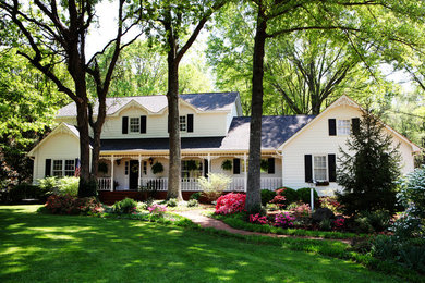 Example of a farmhouse white three-story exterior home design in Charlotte