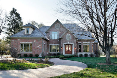Example of a mid-sized classic red two-story brick exterior home design in Chicago