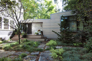 Idée de décoration pour une façade de maison grise minimaliste de plain-pied avec un revêtement mixte.