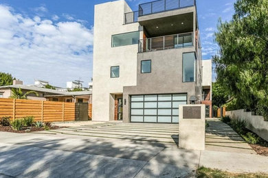 Trendy three-story flat roof photo in Los Angeles