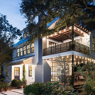 Ejemplo de fachada de casa blanca, de estilo de casa de campo, de tamaño medio, de tres plantas, con revestimiento de madera, tejado a dos aguas y tejado de metal