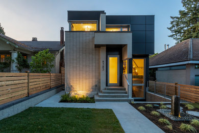 Foto de fachada de casa gris actual de tamaño medio de tres plantas con revestimientos combinados, tejado plano y tejado de varios materiales