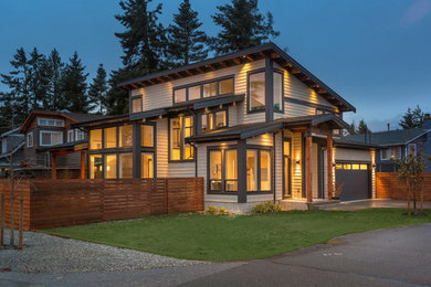 Imagen de fachada de casa beige contemporánea grande de dos plantas con revestimiento de aglomerado de cemento, tejado a dos aguas y tejado de teja de madera