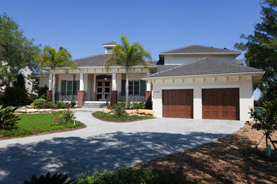 Inspiration for a large and beige traditional two floor render detached house in Tampa with a hip roof and a shingle roof.