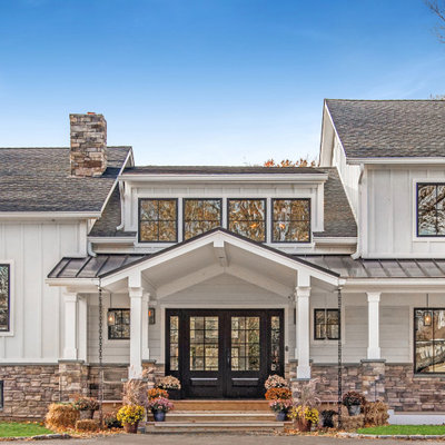 Large country white two-story concrete fiberboard exterior home idea in New York with a mixed material roof